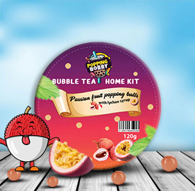 Popping Bobby Passion Fruit Popping Balls with Lychee Syrup (120g) – A rounded container with a colorful lid, decorated with passion fruit and lychee graphics, set against a wooden table and blue sky background.