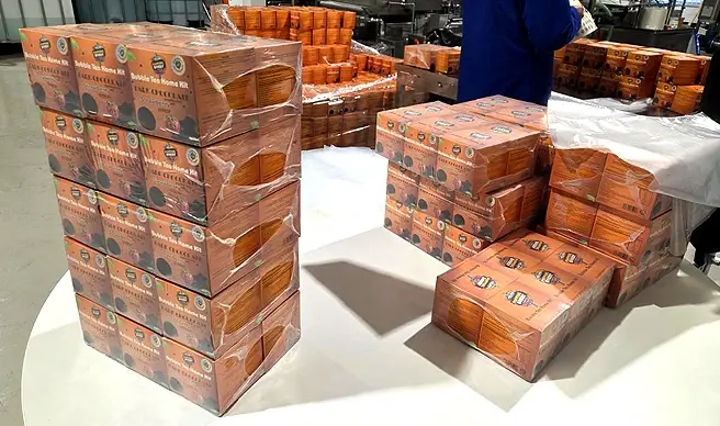Stacks of Popping Bobby bubble tea kits in bulk packaging, shrink-wrapped and ready for wholesale dispatch in a UK facility.